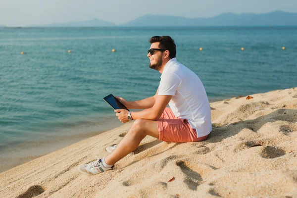 Junger Kerl arbeitet an der Tablette — Stockfoto