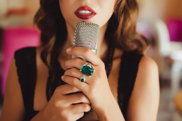 Beautiful girl singing into  microphone — Stock Photo, Image