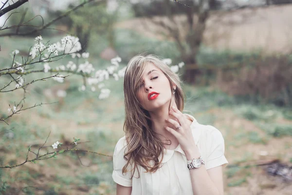 Vacker flicka poserar i blomsterträdgården — Stockfoto