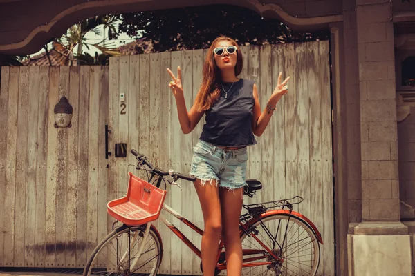 girl posing with  vintage bicycle