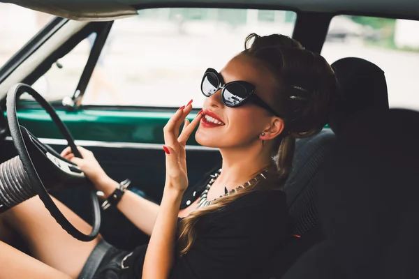 Hermosa chica sentada en un coche vintage — Foto de Stock