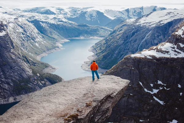 Man posing at troll tongue, at Norway — стоковое фото