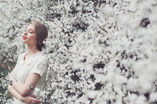 Belle fille posant dans le jardin de fleurs — Photo