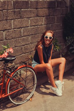 girl  posing with red bicycle