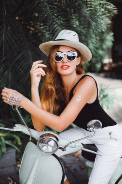 young girl on  vintage scooter