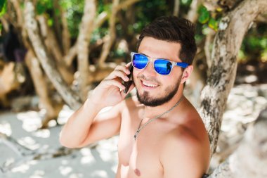 Genç adam telefonda konuşuyor.