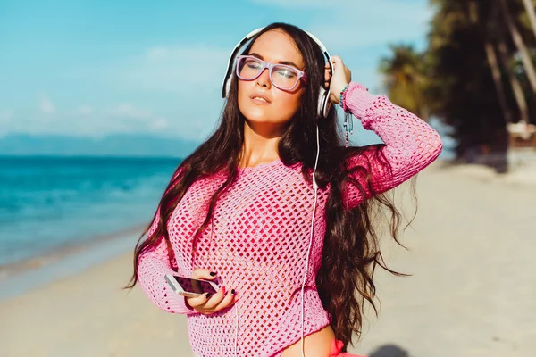 Chica escuchando música en la playa — Foto de Stock