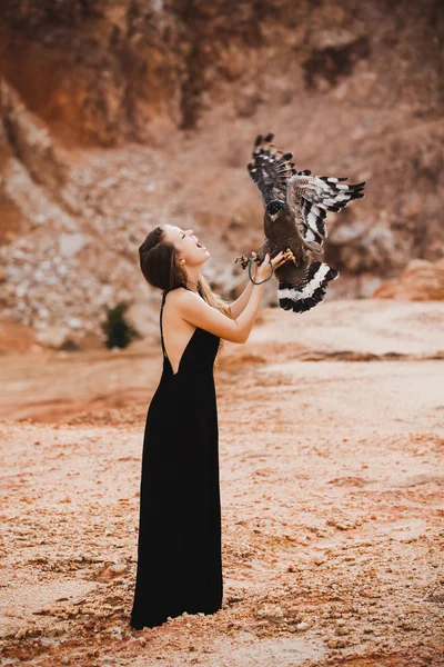Mulher segurando águia em sua mão — Fotografia de Stock