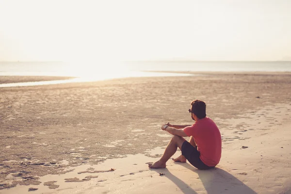 Jonge man in zonnebril bij zonsondergang — Stockfoto