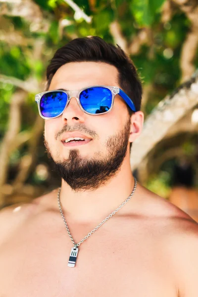 Uomo in occhiali da sole in spiaggia — Foto Stock