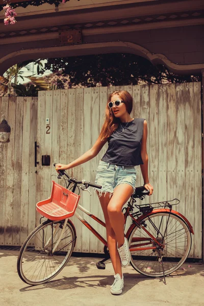 Девушка позирует с винтажным велосипедом — стоковое фото