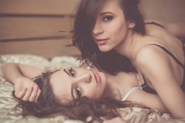 Girls posing together on bed — Stock Photo, Image