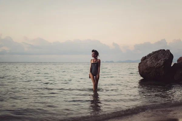 Bruneta pózuje na pláži — Stock fotografie