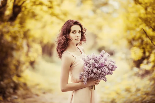 Ung flicka med bukett blommor — Stockfoto