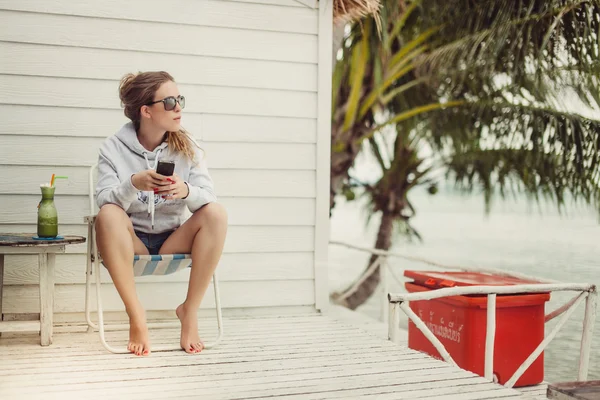 Молодая девушка в солнечных очках с телефоном — стоковое фото