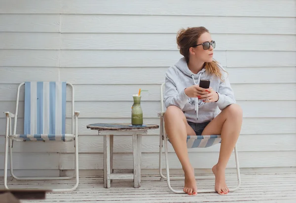 Молодая девушка в солнечных очках с телефоном — стоковое фото