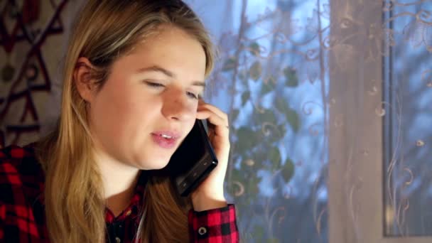 Uśmiechnięta młoda kobieta siedzi na kanapie mówić na telefon — Wideo stockowe