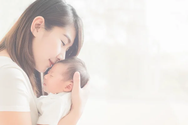 Happy mother holding adorable child baby boy