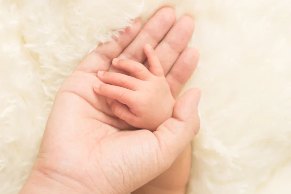 Mano del bebé dormido en la mano de la madre de cerca — Foto de Stock