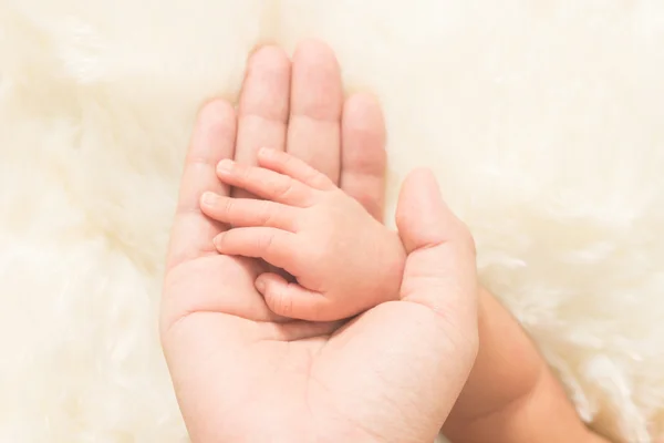 Mano del bebé dormido en la mano de la madre de cerca — Foto de Stock