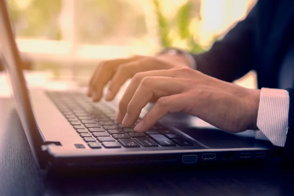 Mãos de homem digitando no teclado do laptop — Fotografia de Stock