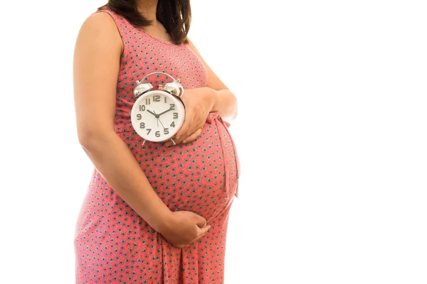 Mujer embarazada sosteniendo reloj de pared. Es la hora. Aislado sobre blanco . — Foto de Stock