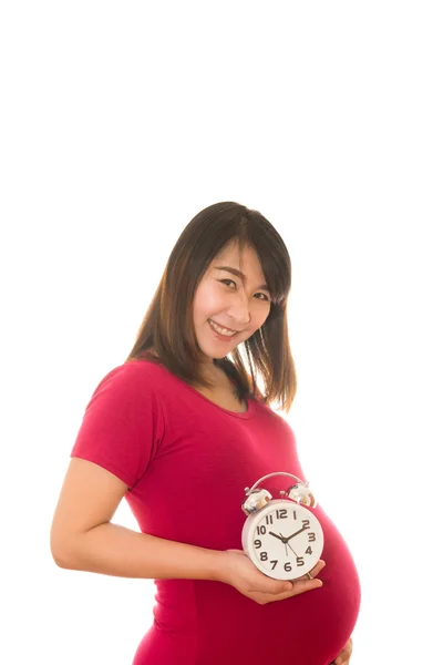 妊娠中の女性は、壁掛け時計を保持しています。時間です。白で隔離. — ストック写真