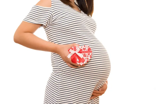 Mujer embarazada vientre sosteniendo el corazón de regalo. aislado en blanco — Foto de Stock