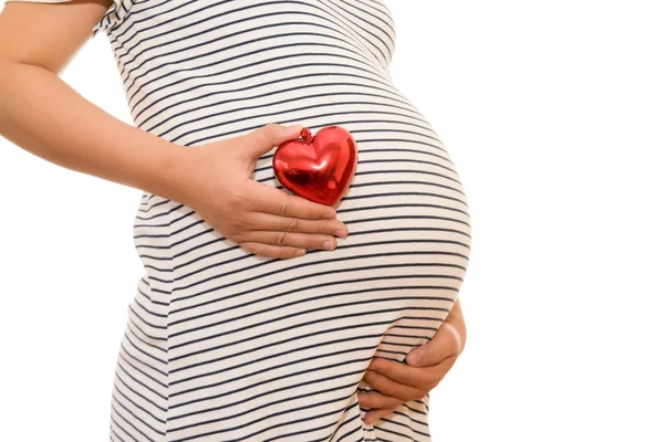 Mujer embarazada vientre sosteniendo el corazón de regalo. aislado en blanco — Foto de Stock