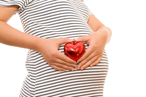 Mujer embarazada vientre sosteniendo el corazón de regalo. aislado en blanco — Foto de Stock