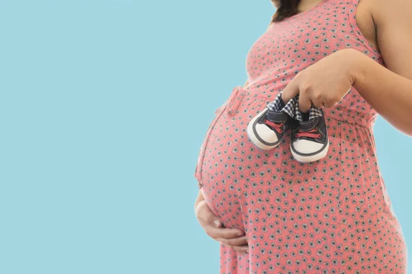 Małe buty dla nienarodzonego dziecka w brzuchu o kobiety w ciąży Obraz Stockowy