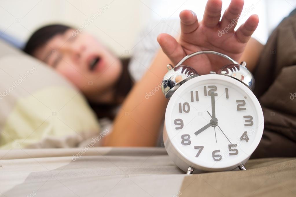 Young woman getting stressed about waking up too early, shallow 