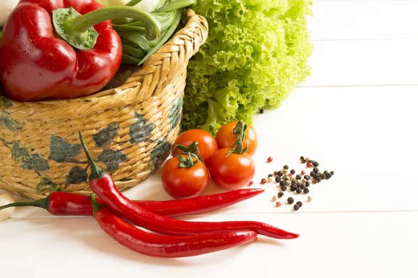 Verdure di insalata di pepe in un cesto di vimini su un tavolo di legno — Foto Stock