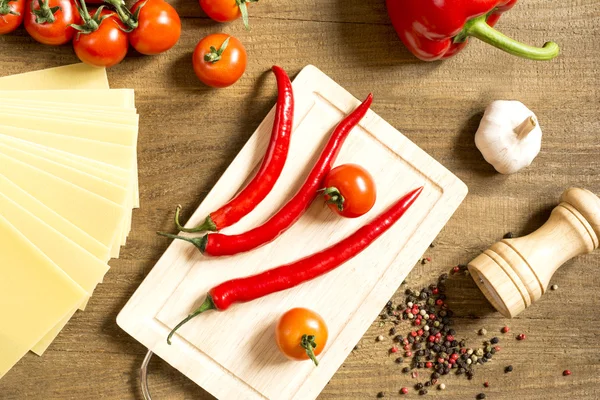 Processo de cozimento nos produtos de cozinha espalhados na mesa de madeira áspera — Fotografia de Stock