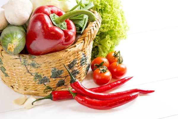 Paprika salade groenten in een rieten mand op een houten tafel — Stockfoto