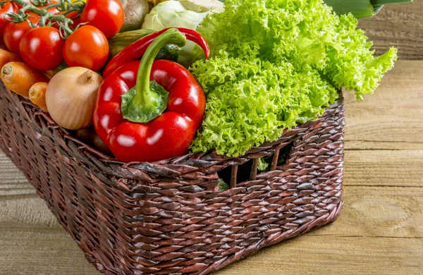 Cesta de vime com frutas e legumes na mesa — Fotografia de Stock