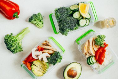 Sebze, pirinç, açık beyaz arka planda plastik kaselerde et.