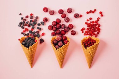 Vişneli üzümlü üzümlü üzümlü waffle fincanının üstünde pembe arka planda