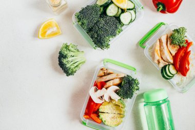 Sebze, pirinç, açık beyaz arka planda plastik kaselerde et.