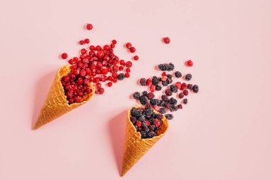 Vişneli üzümlü üzümlü üzümlü waffle fincanının üstünde pembe arka planda