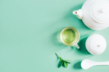 Yeşil zemin üzerinde çay olan çay fincanının çay fincanının en üst görüntüsü.