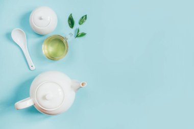 Çay takımının üst görüntüsü çaydanlık şekerliği fincanı mavi arkaplanda çay ile
