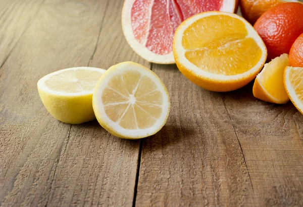 Нарізаний лимон на фоні цитрусових на дерев'яному та — стокове фото