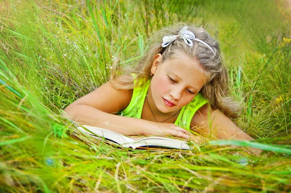 Menina lendo um livro sobre a natureza — Fotografia de Stock