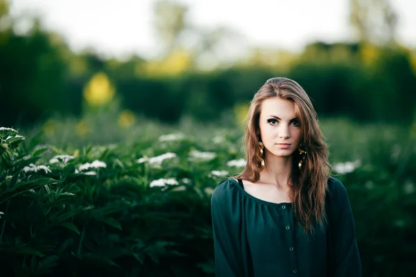 Vacker ung kvinna poserar i en blommande våren park — Stockfoto