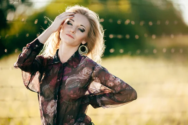 Belle jeune femme posant dans un parc printanier fleuri — Photo