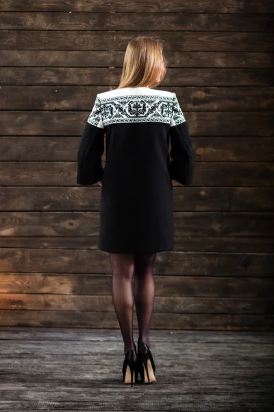 Молодая блондинка в черно-белом платье позирует на сером бэкгре — стоковое фото