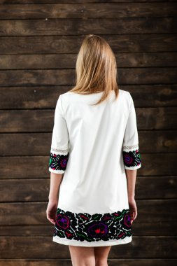 Gri arka plan üzerinde poz siyah beyaz elbiseli genç sarışın Bayan