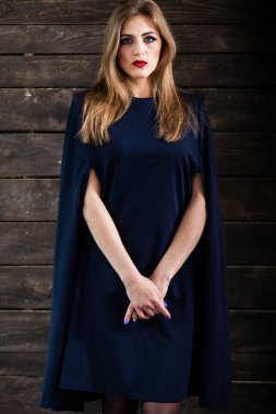 Gri arka plan üzerinde poz siyah beyaz elbiseli genç sarışın Bayan