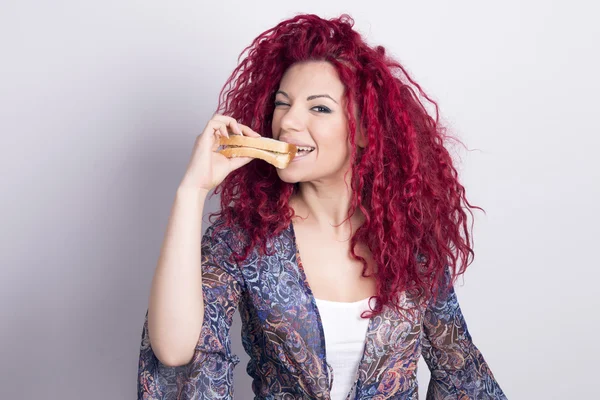 Забавная женщина ест сэндвич в помещении . — стоковое фото